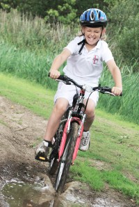girl riding through puddle